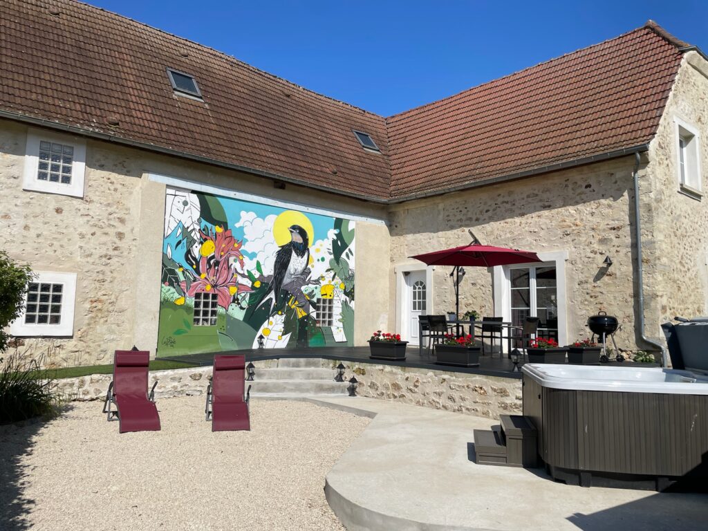 Jacuzzi privatif extérieur de L'Hirondelle au Domaine d'Ailleurs, week-end romantique en Champagne avec deux coupes de Champagne